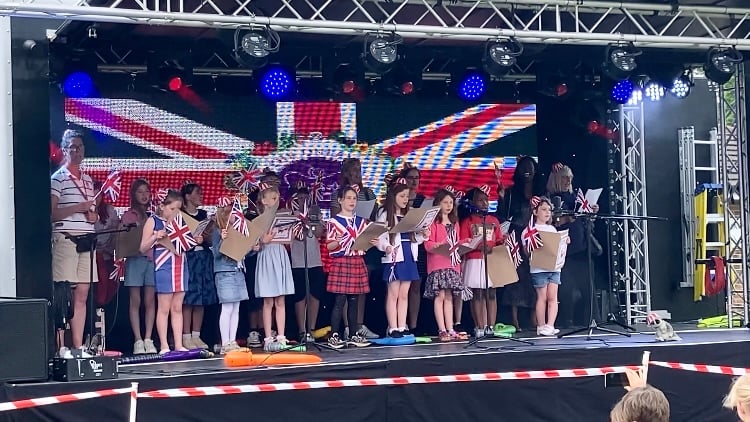 Woodlea School Choir and Cllr Bisi Kennard sing the national anthem during the Whitehill & Bordon Platinum Jubilee music festival at Mill Chase Recreation Ground in Bordon on June 3rd 2022.