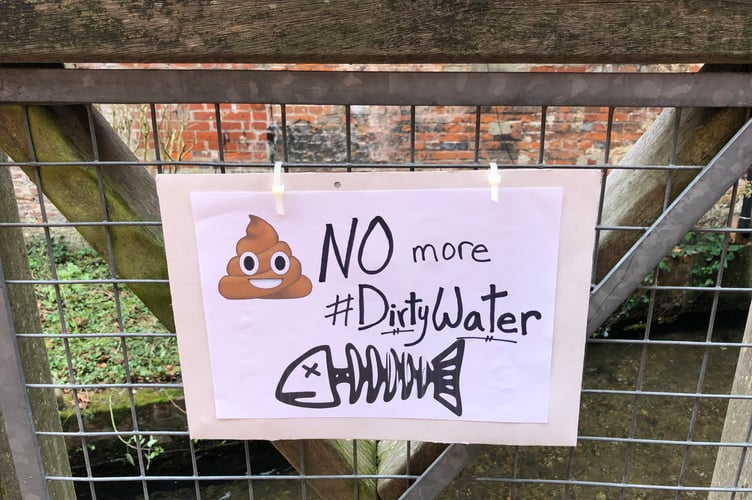 An Extinction Rebellion poster by the River Wey in Alton